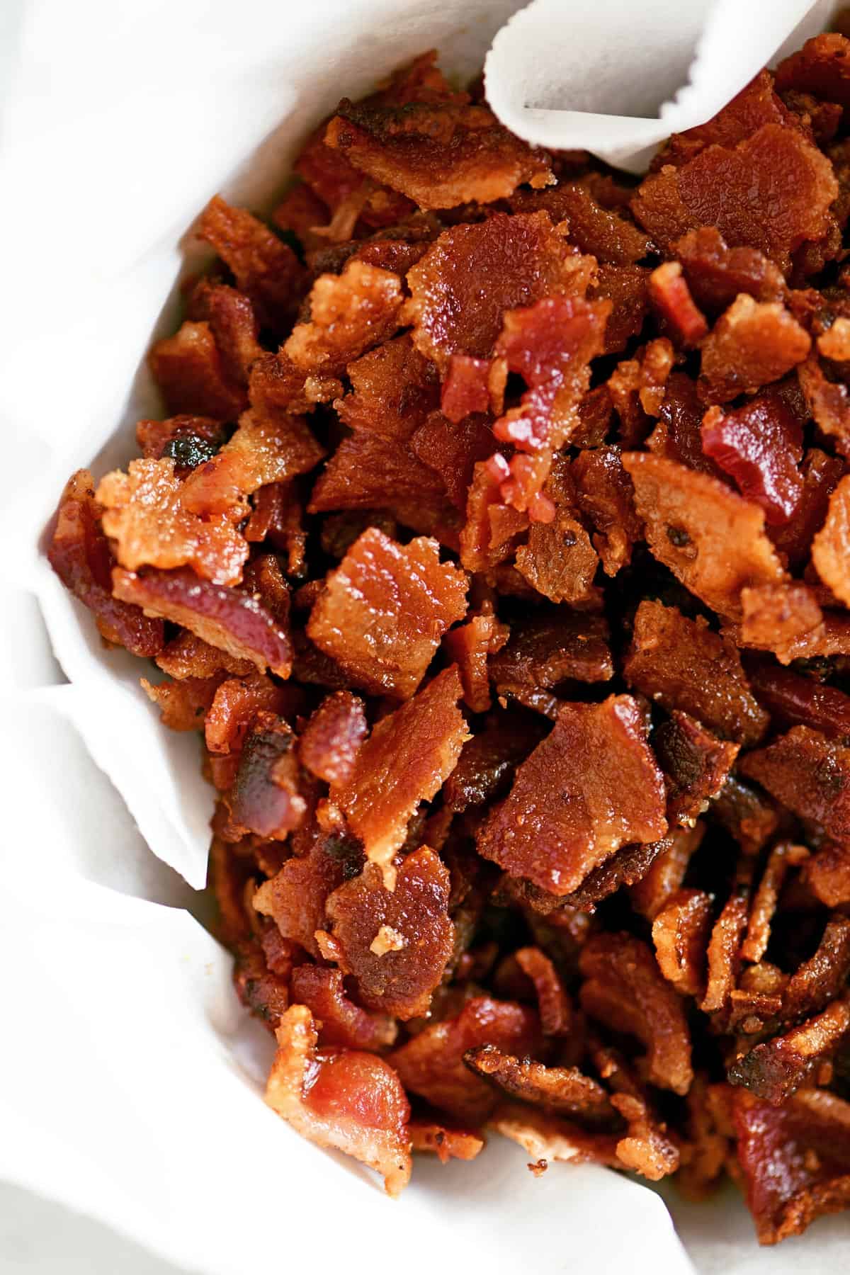Crumbled bacon in a parchment-lined bowl.