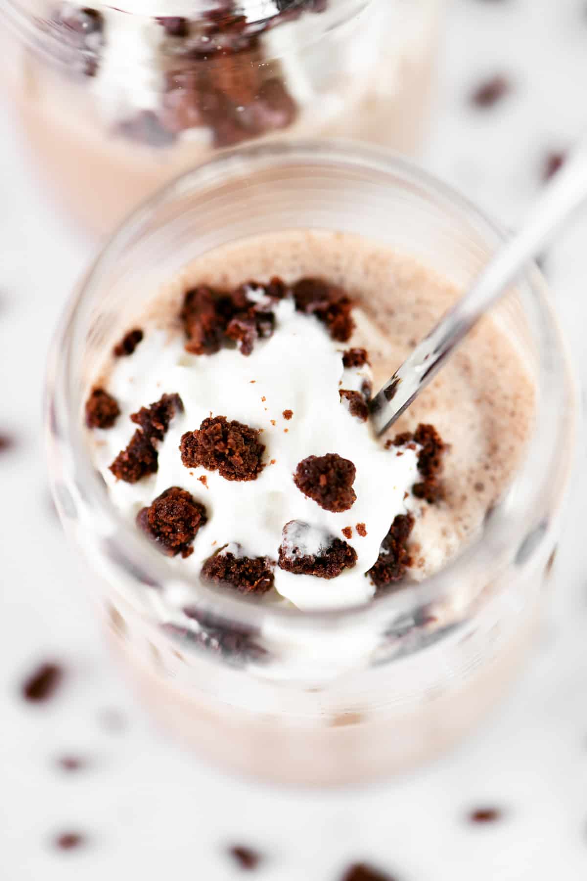 Showing inside a glass filled with a brownie milkshake.