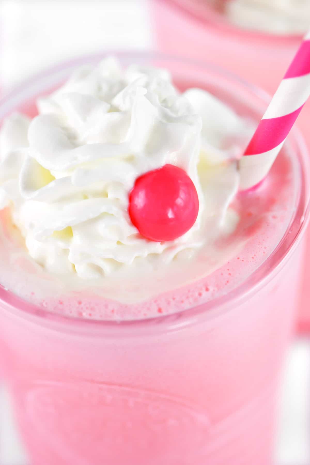 A pink gum ball on a bubblegum milkshake.