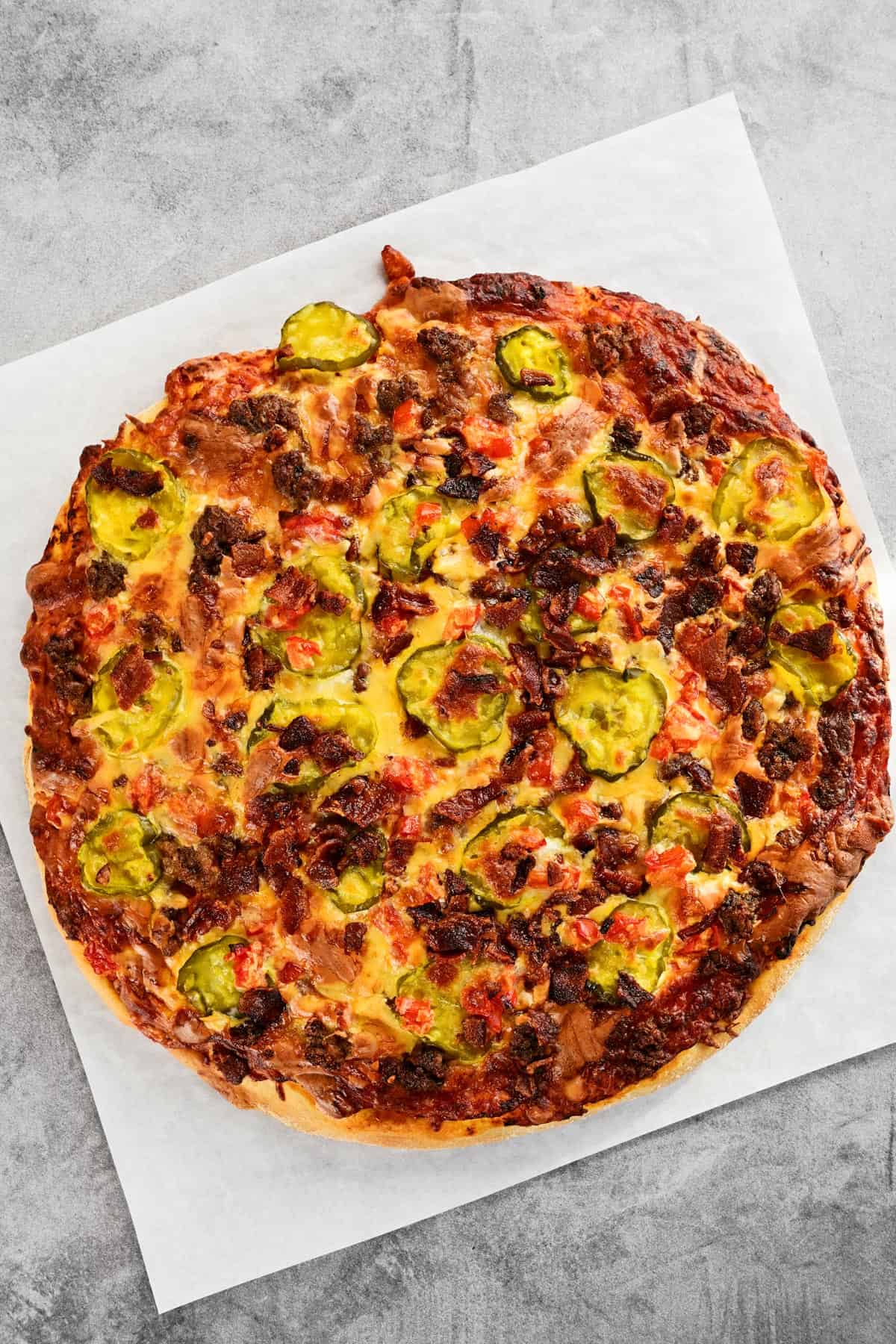 A cooked pizza with meat and vegetables on top.