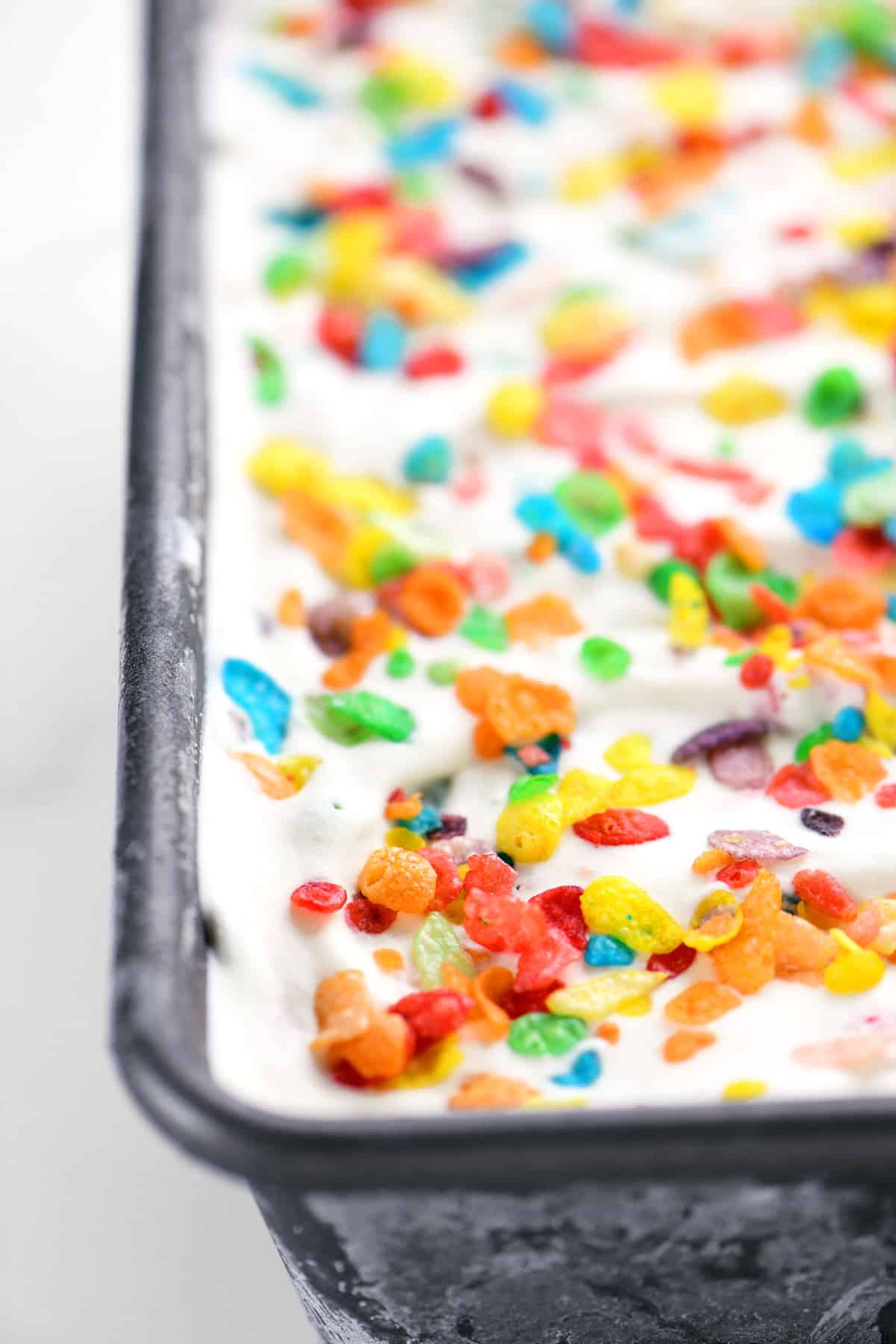 Fruity Pebbles cereal on top of ice cream.