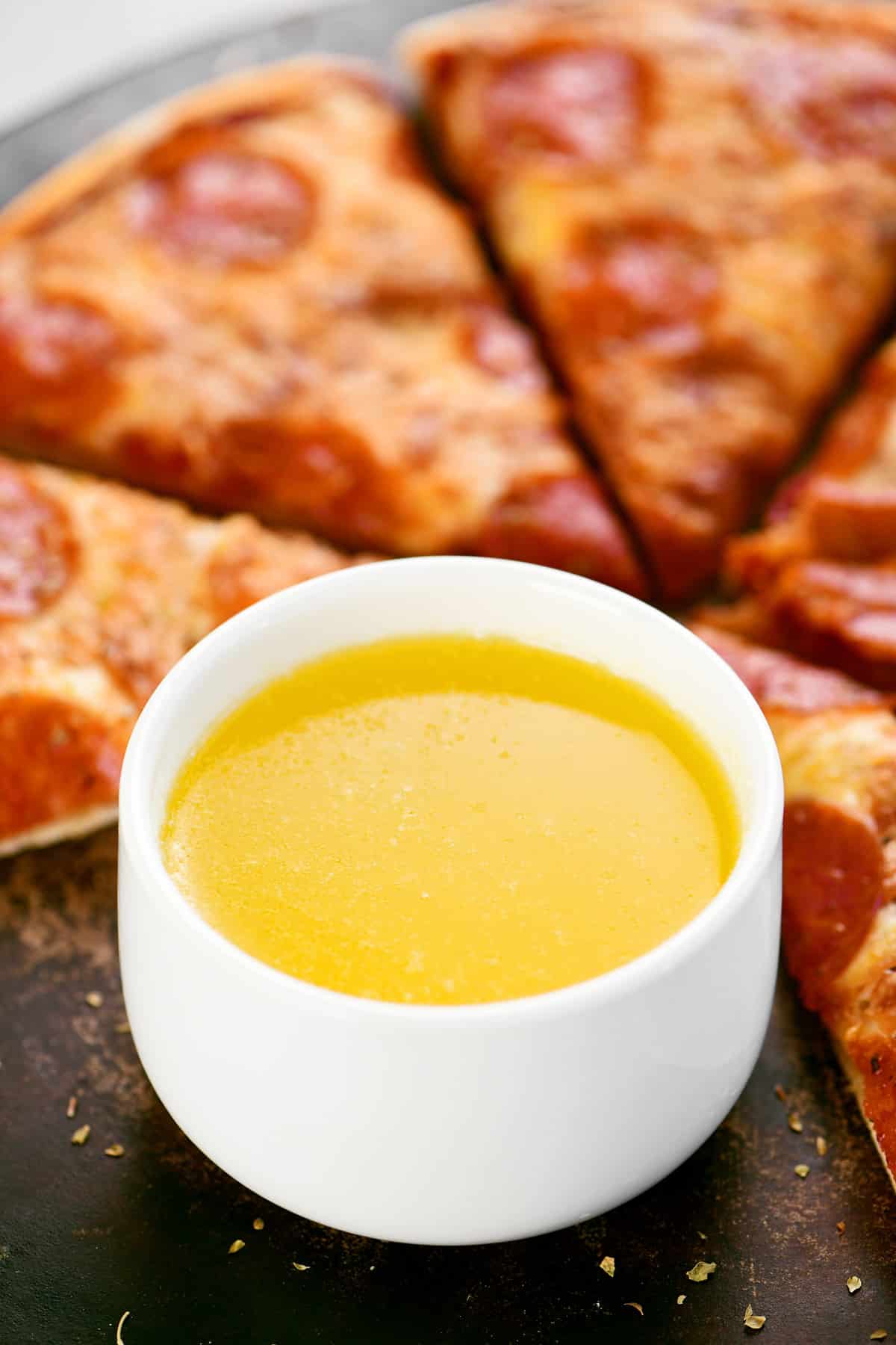 A bowl with pizza dipping sauce in it.