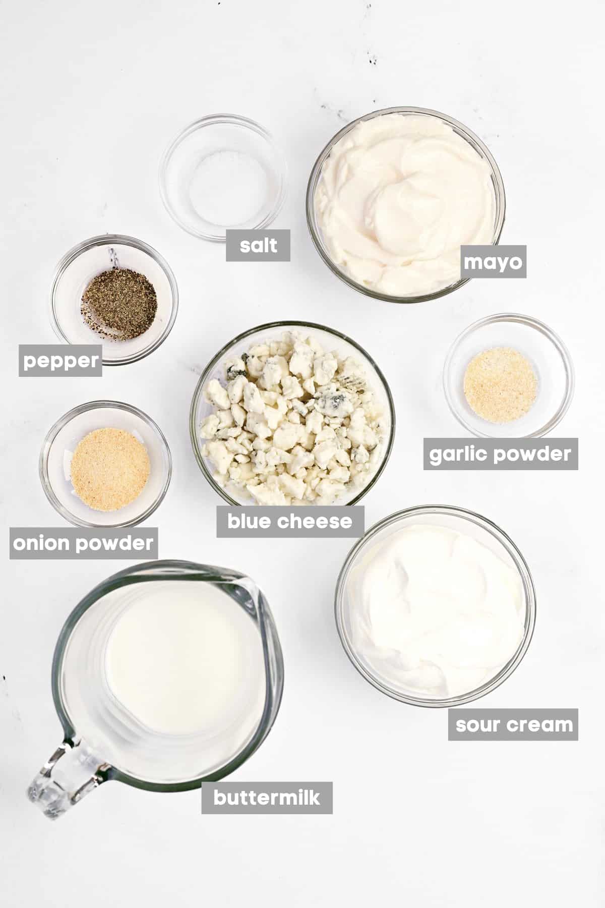 Labeled ingredients in glass bowls on a white counter.
