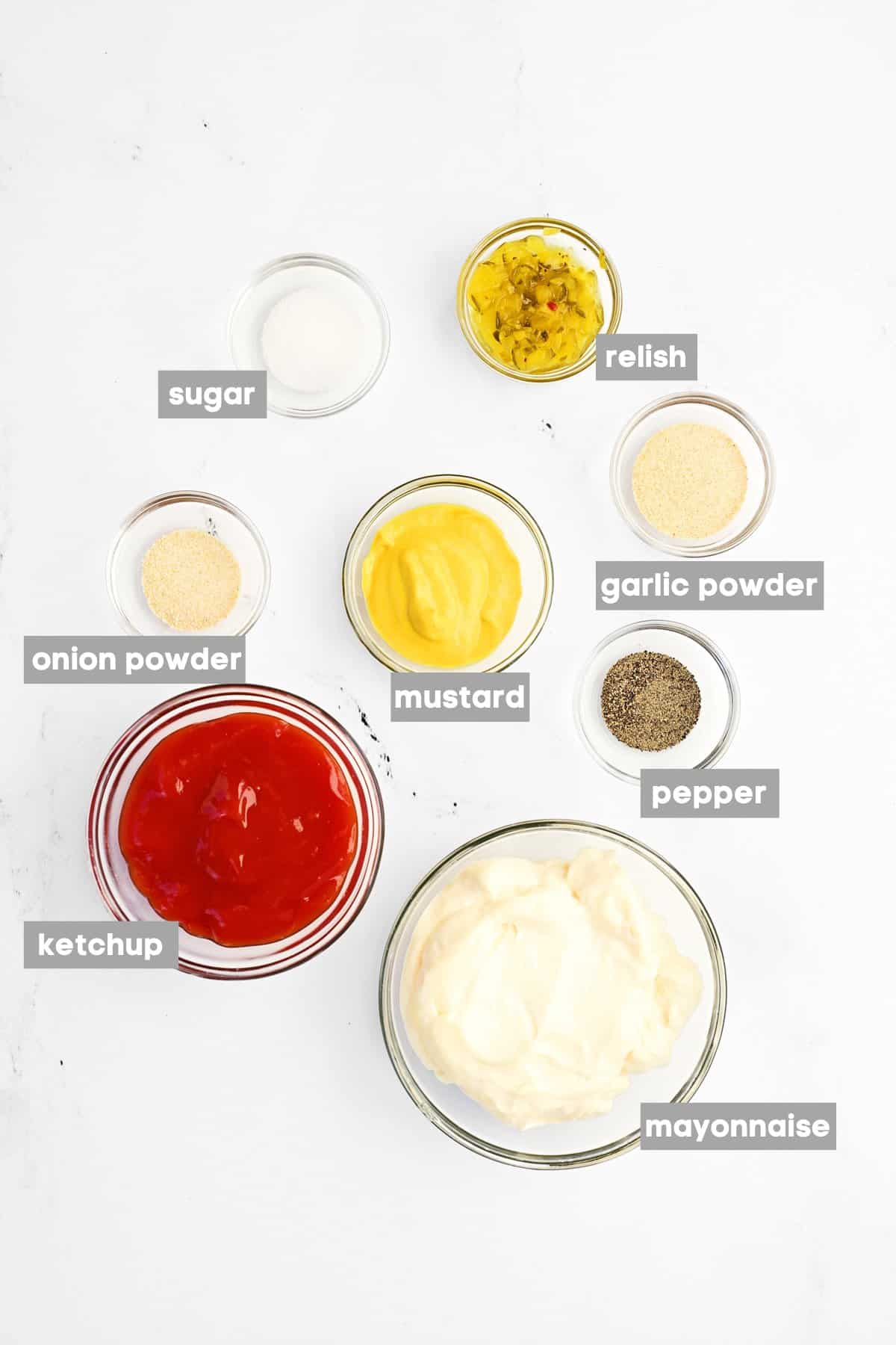 Eight ingredients in small glass bowls on a counter.
