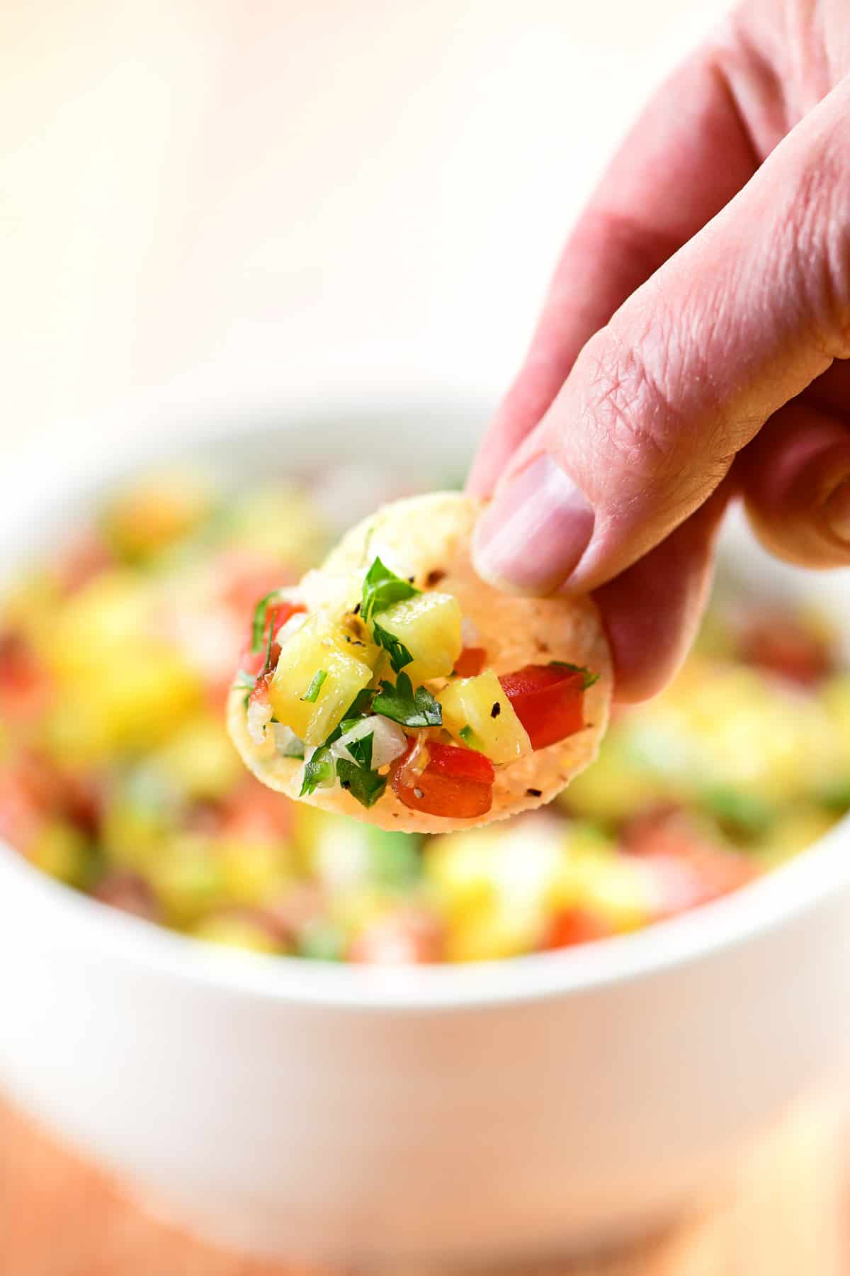 A chip with pineapple pico de gallo on top.