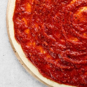 Pizza dough with pizza sauce.