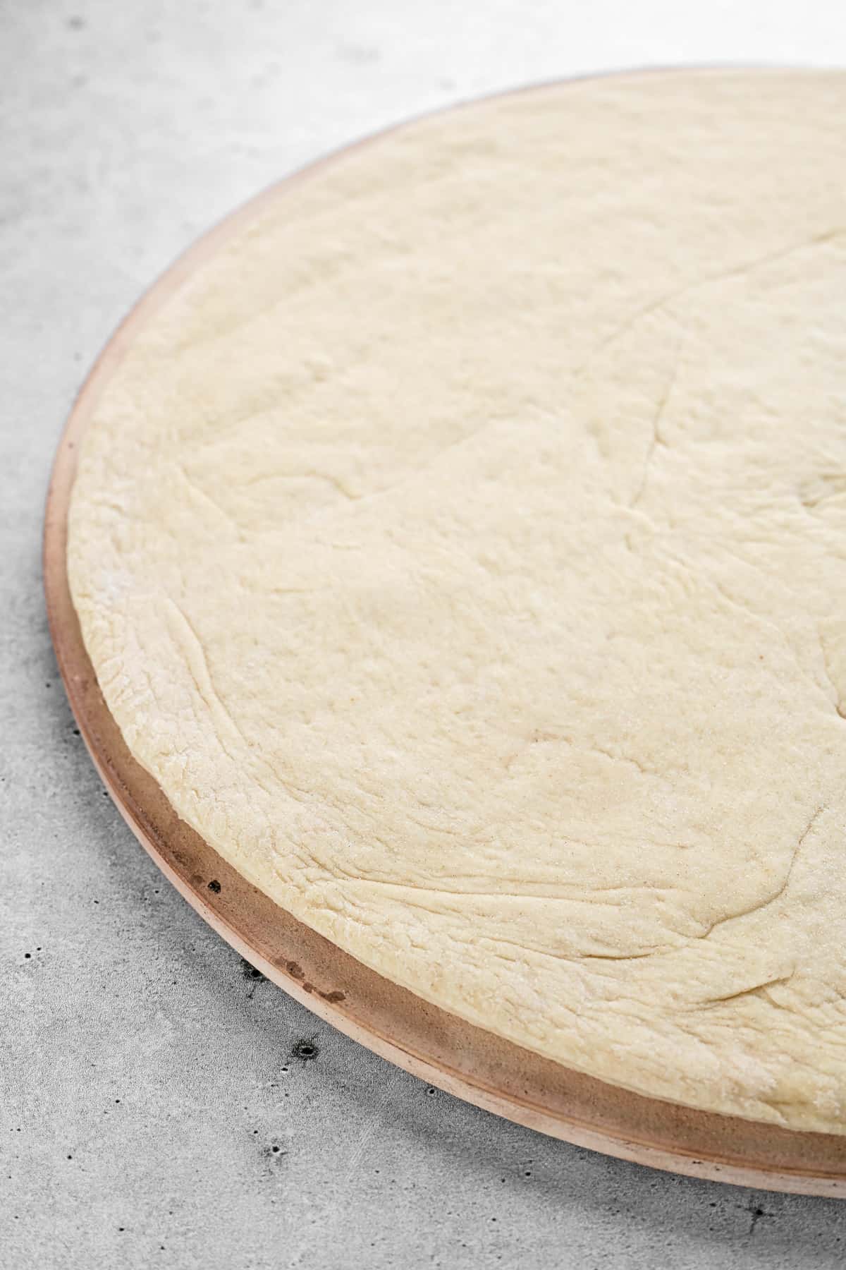 Pizza dough on a cooking stone.