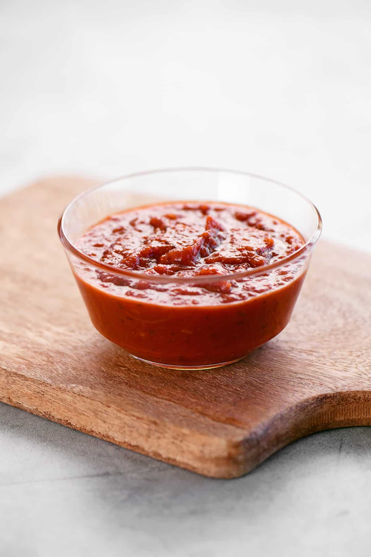 Pizza sauce in a plastic dipping bowl.