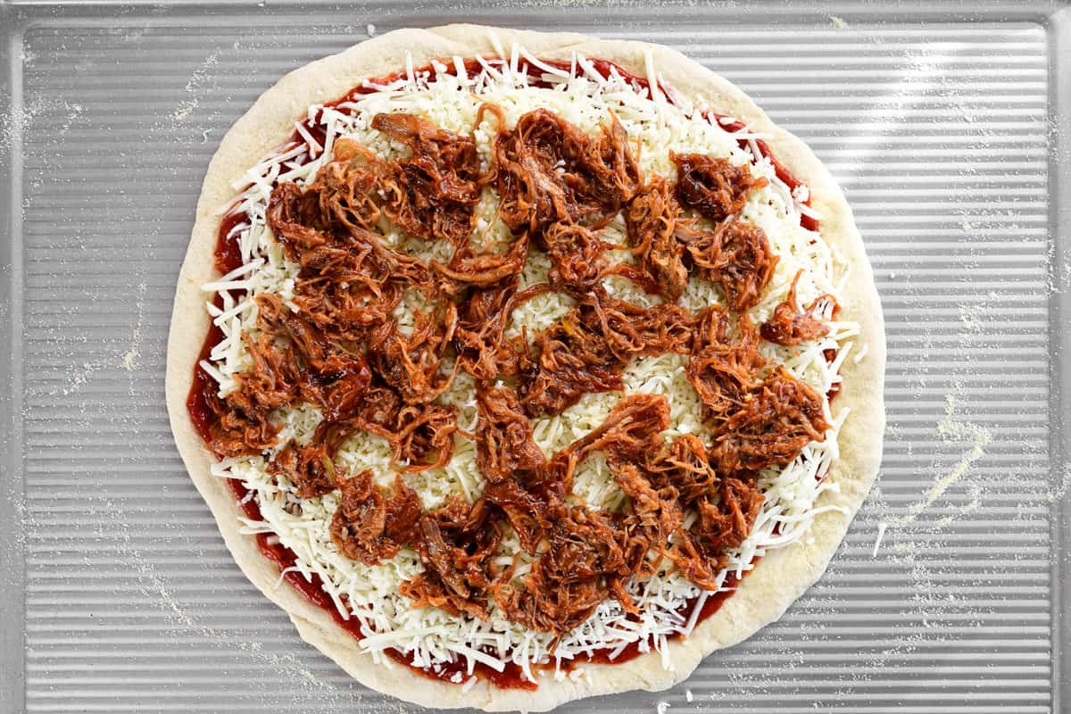 Add the bbq pulled pork to the pizza.