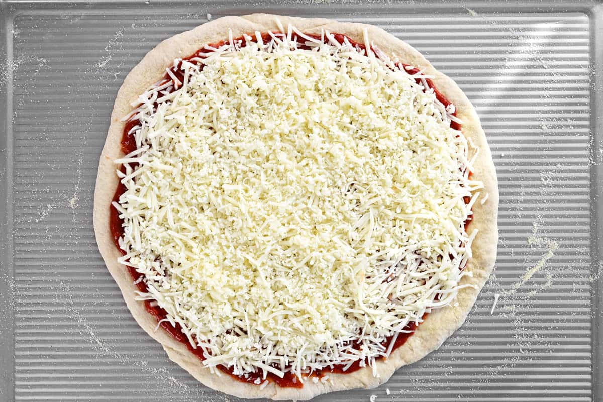 Shredded cheese on a pizza.