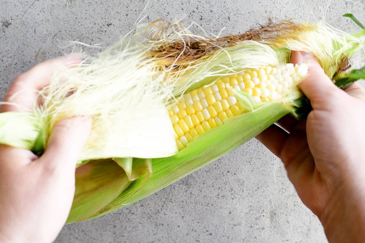 Shucking sweet corn.