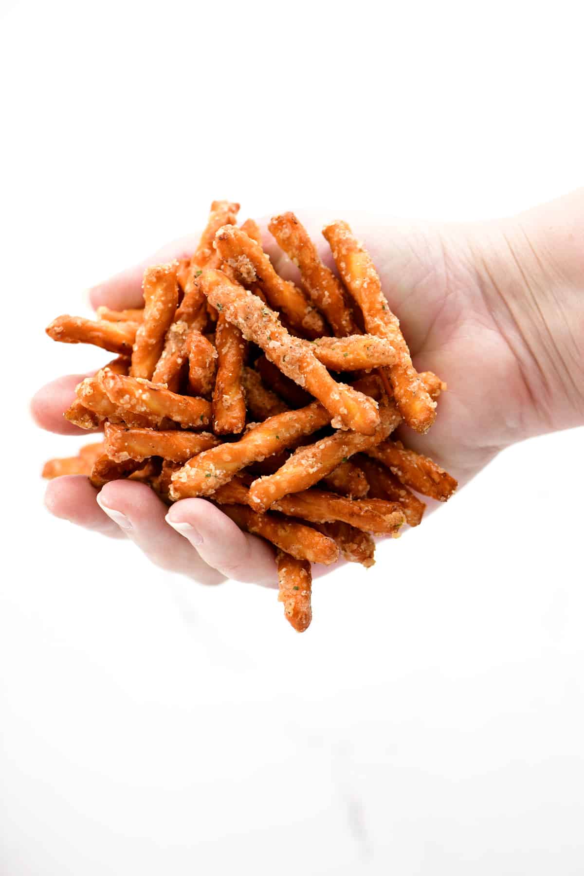 A hand holding spicy pretzels.