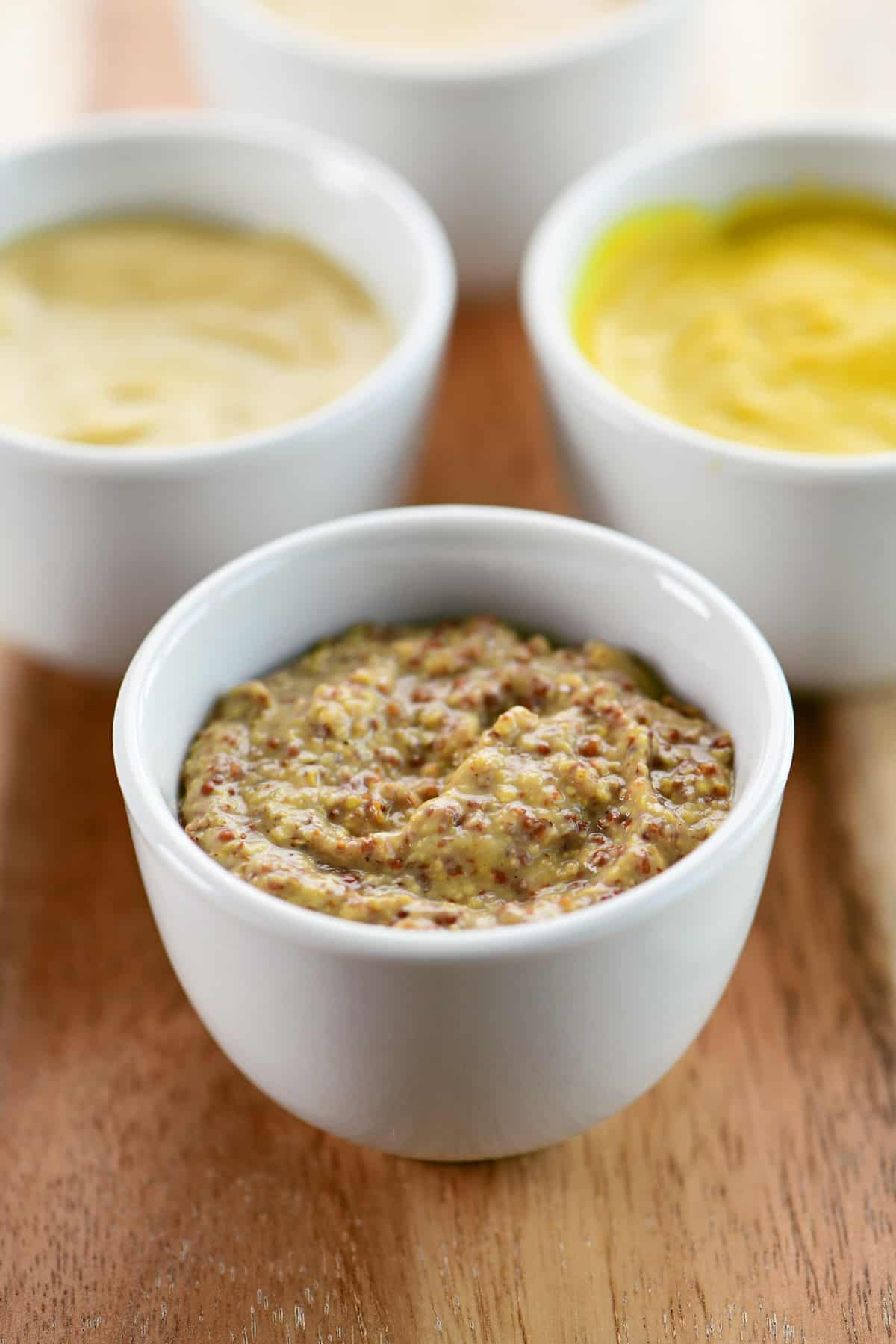 Stone ground mustard in a small white condiment bowl.