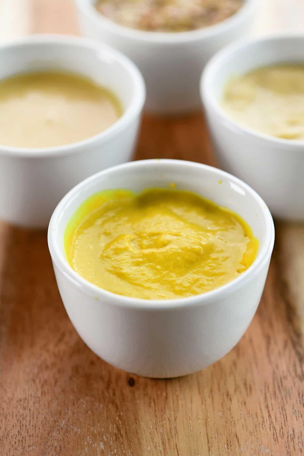 Yellow mustard in a small white condiment bowl.
