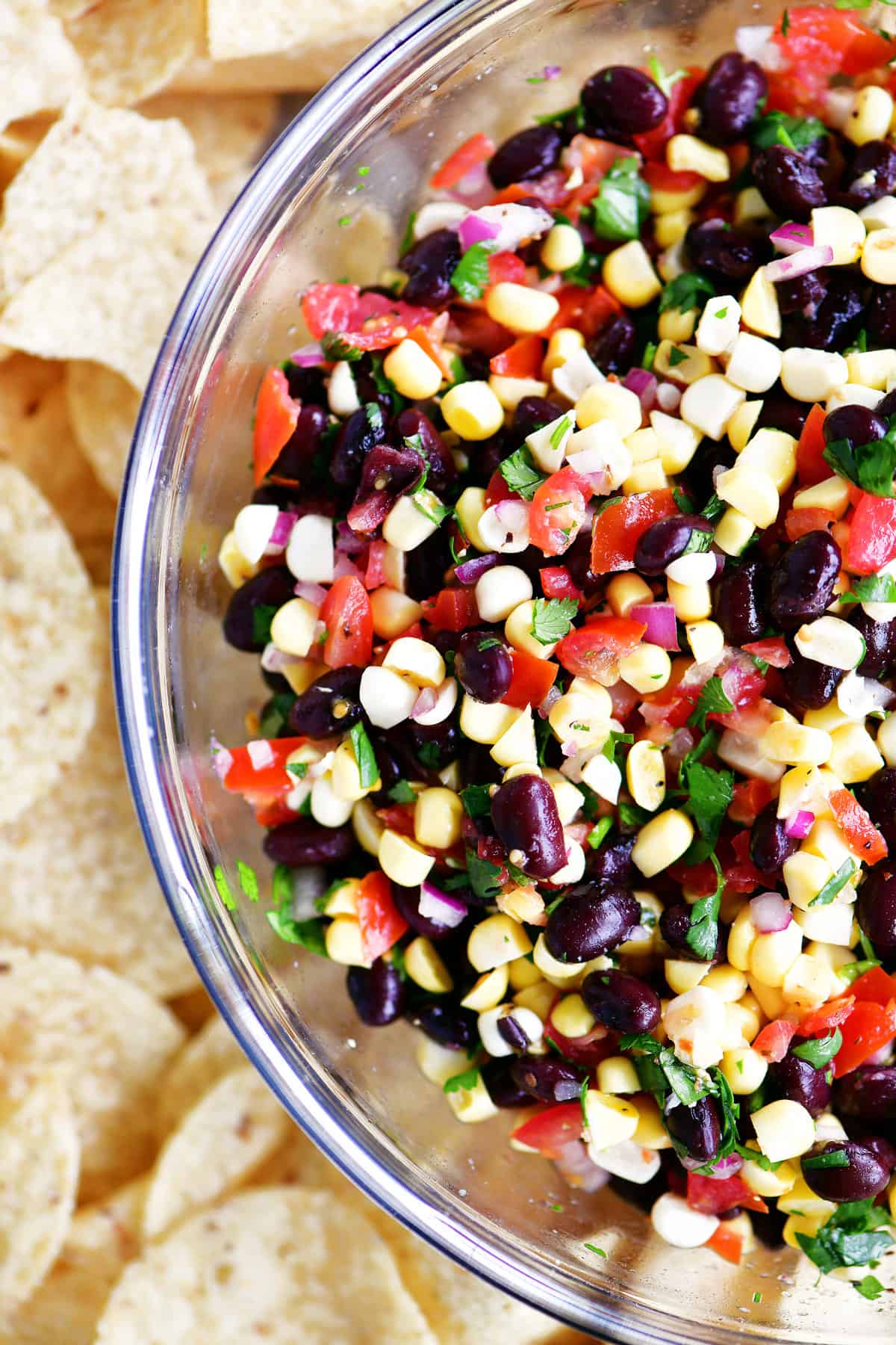 Showing half of the bowl of black bean corn salsa with chips.