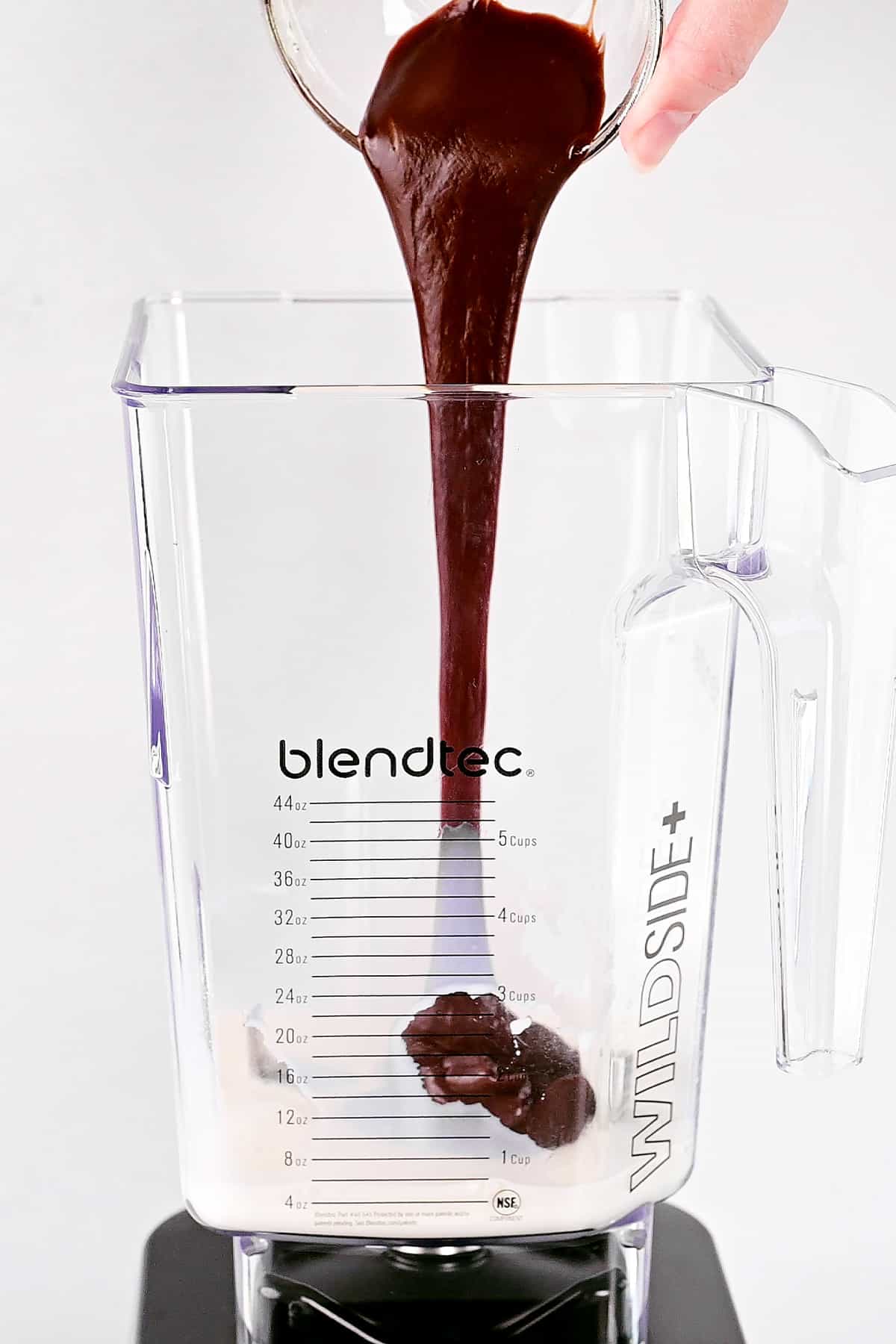 Pouring chocolate sauce into blender.