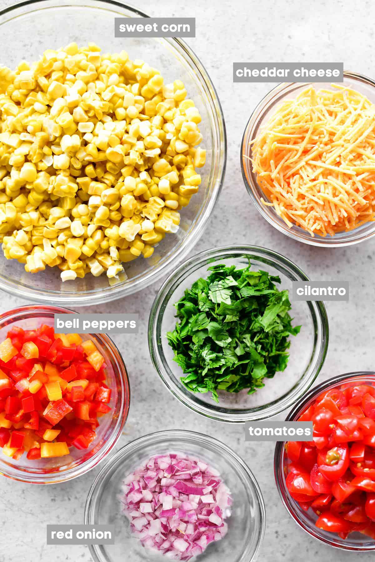 Prepped ingredients in bowls on a stainless steel countertop.