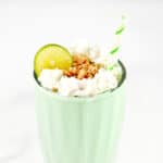 A key lime milkshake in a glass with toppings.