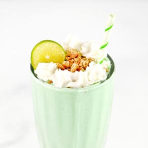 A key lime milkshake in a glass with toppings.
