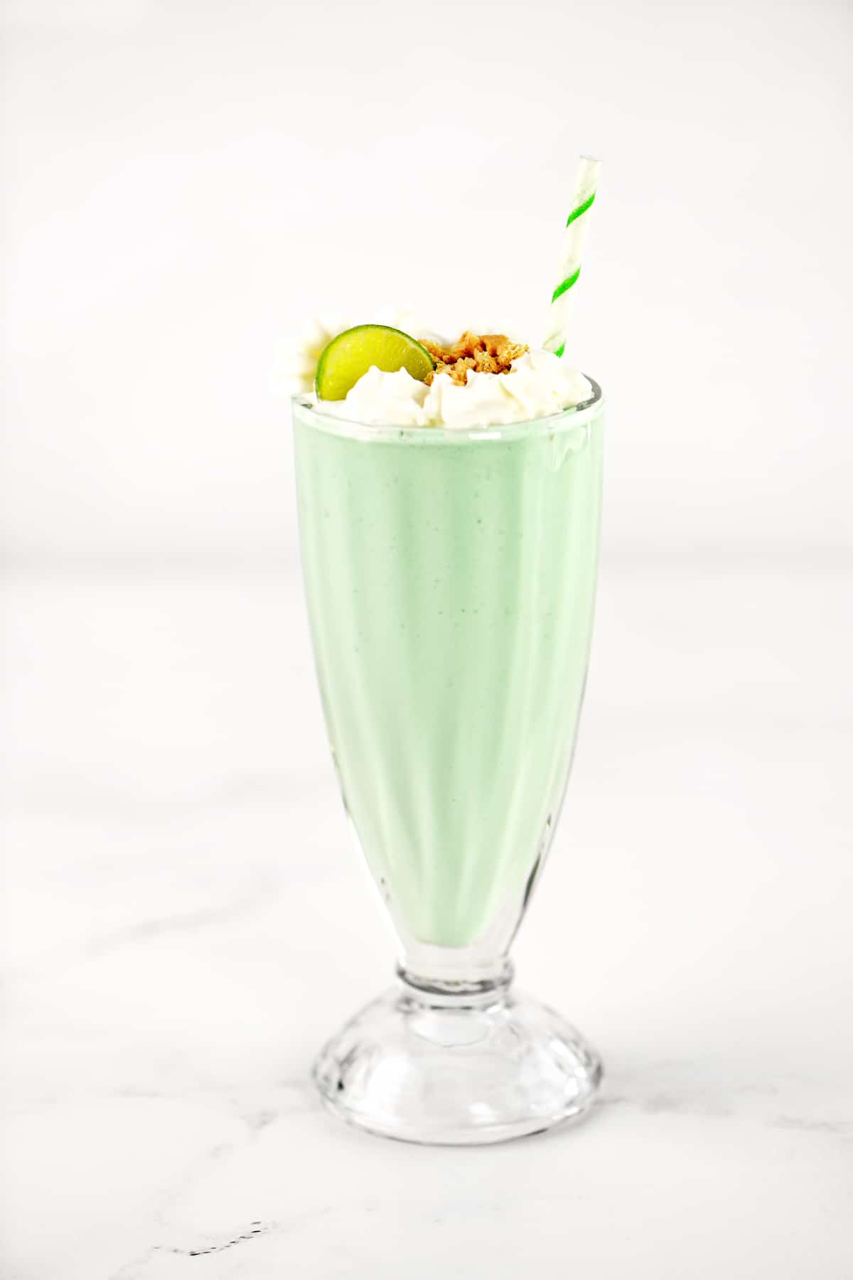 A key lime milkshake in a glass.