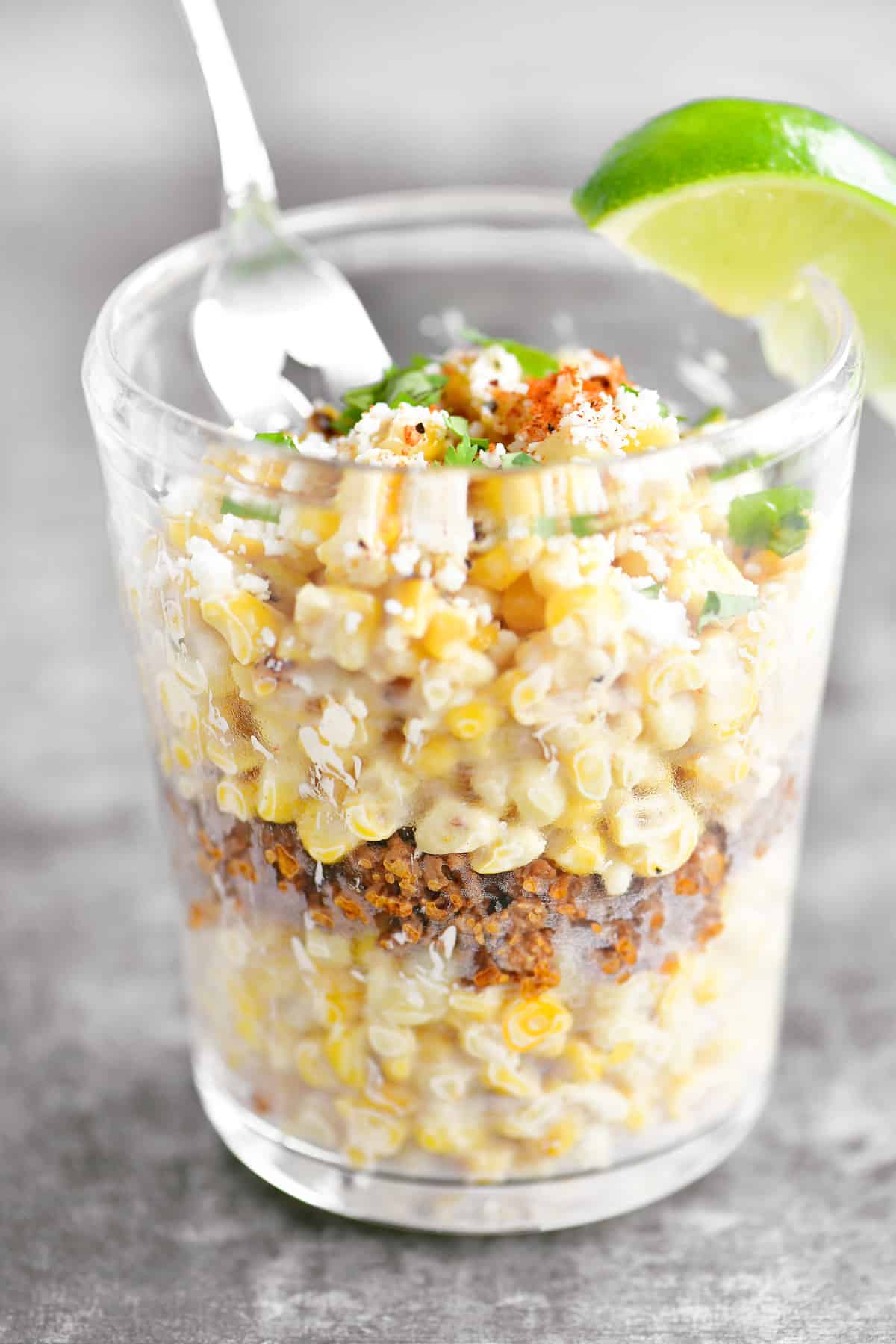 Mexican corn in a cup with a fork.