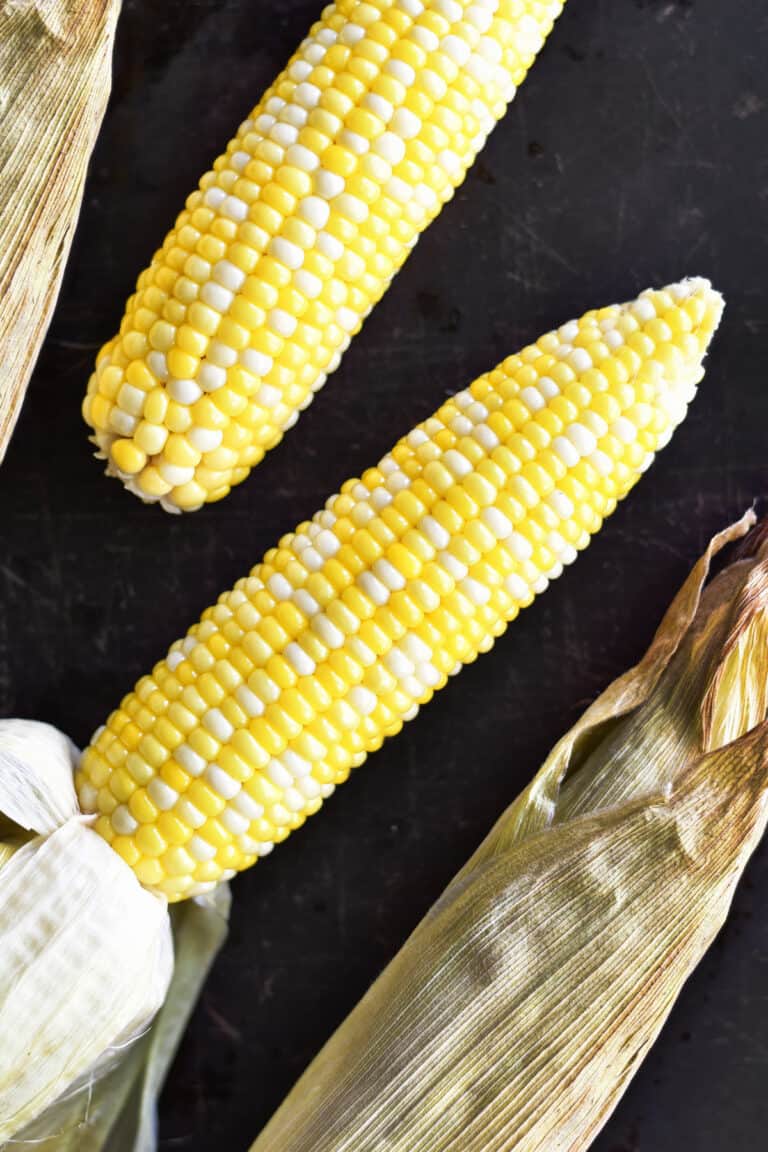 Oven roasted corn on the cob in husks.