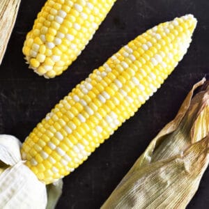 Oven roasted corn on the cob in husk.