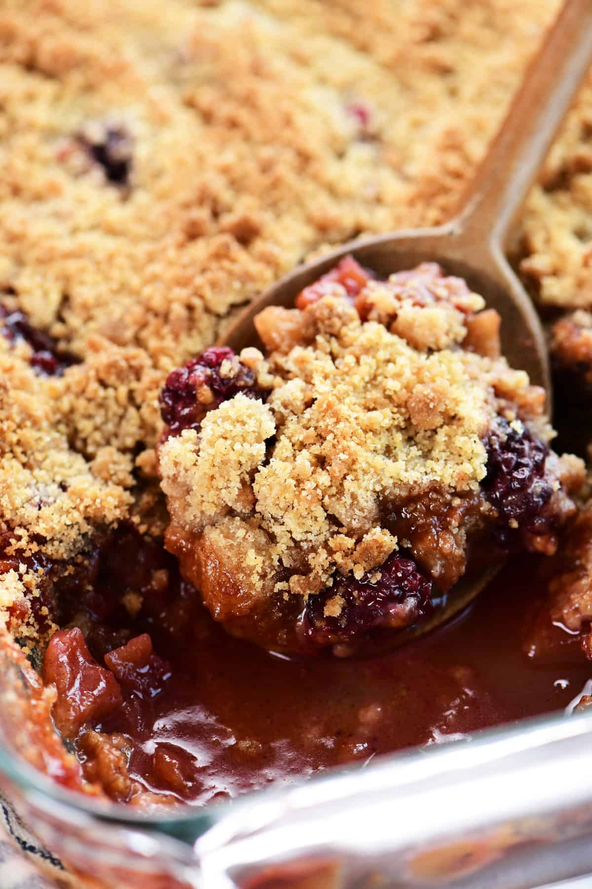 A spoon full of apple blackberry crumble.