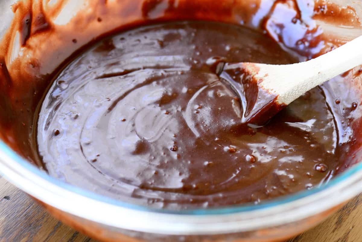 Mixing batter in a bowl with a wooden spoon.