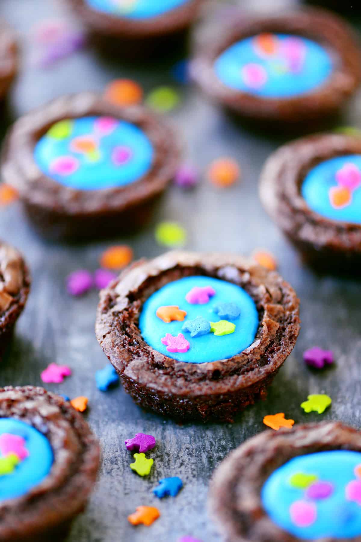 Brownie bites filled with blue frosting and fish sprinkles on top.