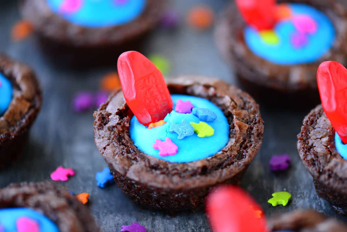 Brownie bites with blue frosting, fish sprinkles, and gummy fish.