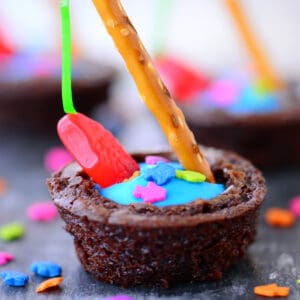 Brownie bite with frosting and gummy fish.