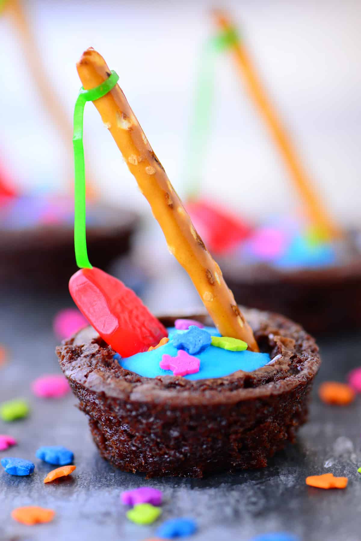 Brownie bite with frosting and gummy fish.