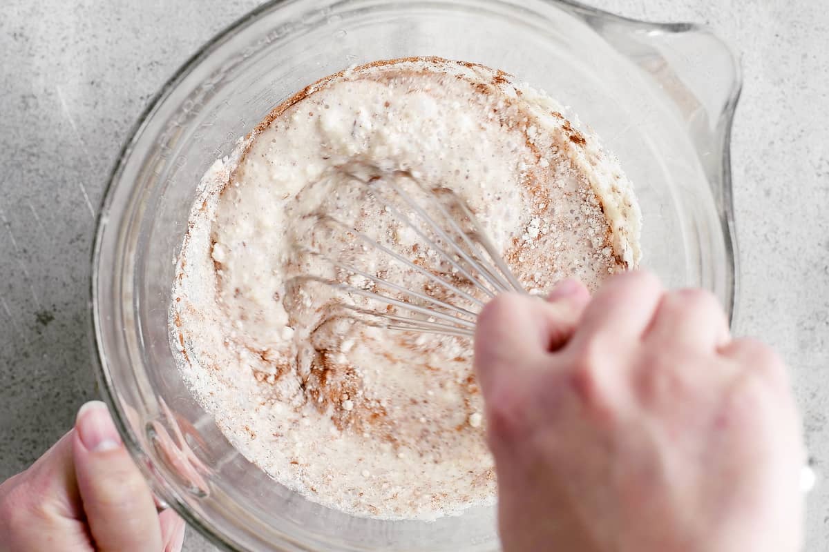 A hand whisking the batter in a bowl.