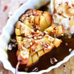 A bloomin' baked pear with caramel sauce and chopped pecans on top.