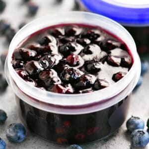 A small container with blueberry pie filling inside.