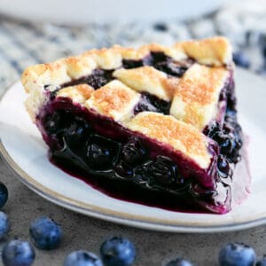 A slice of blueberry pie on a small plate.