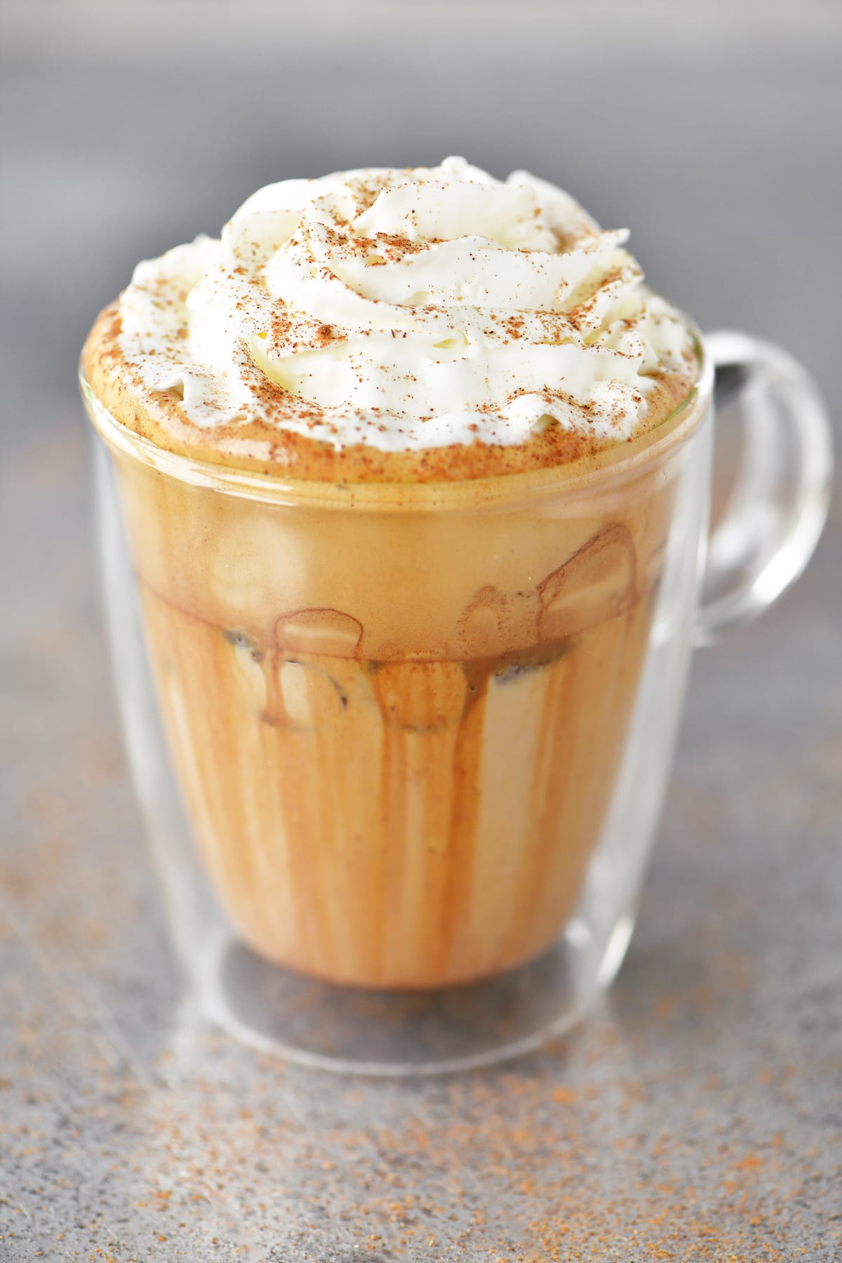 Iced pumpkin spice latte in a glass mug.