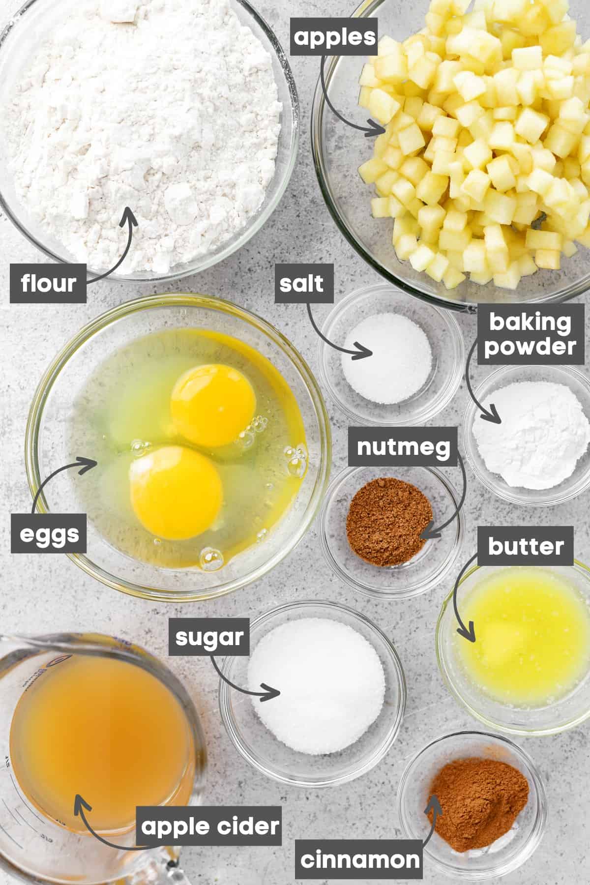 Labeled ingredients in bowls on a stainless steel countertop.