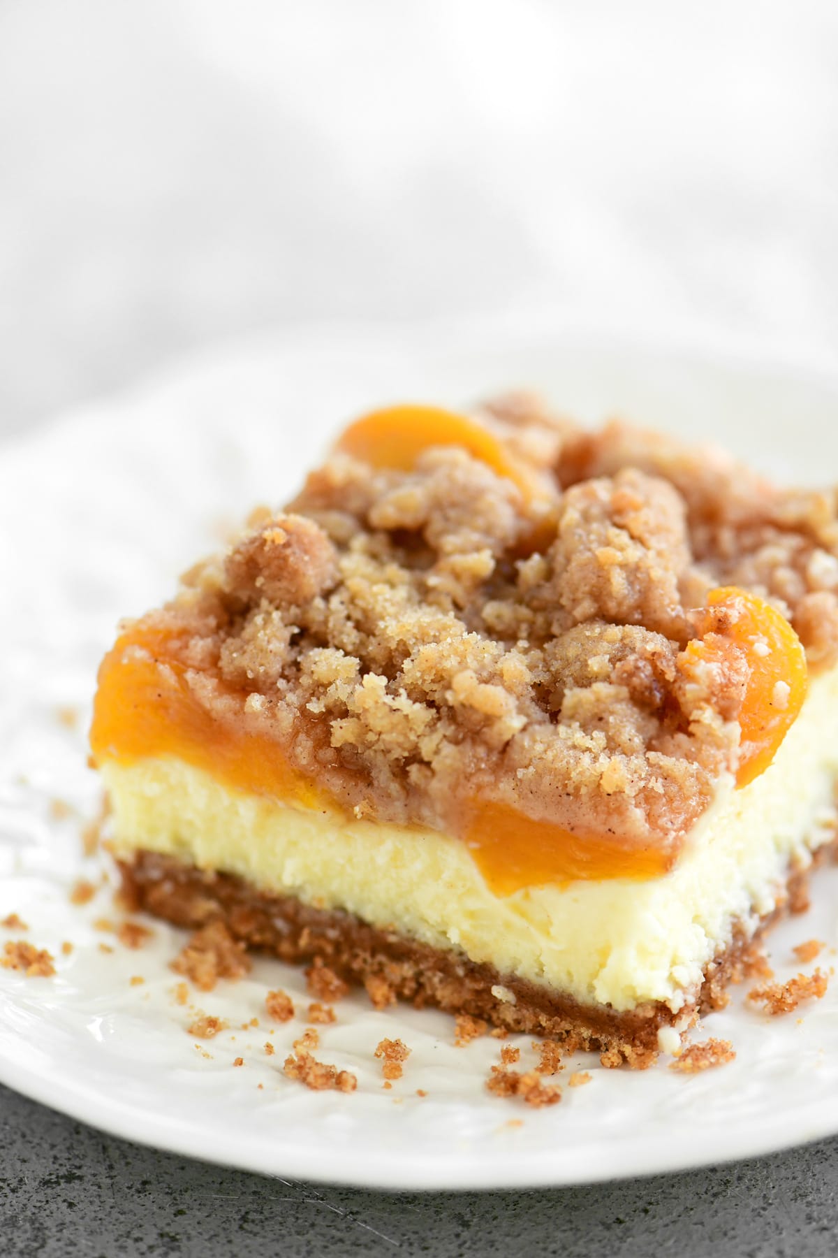 A slice of peach cobbler cheesecake on a plate.