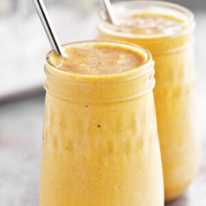 Two glass jars filled with pumpkin pie smoothie.