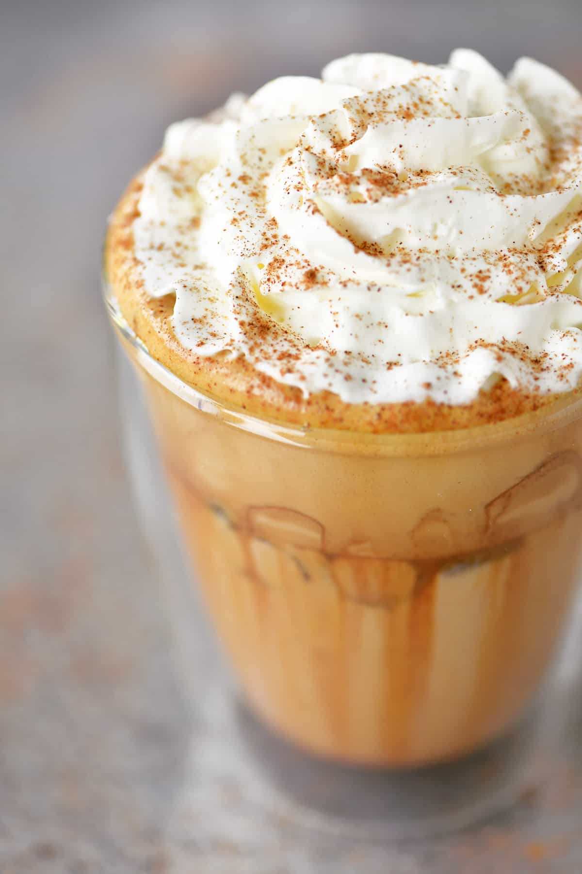 Iced pumpkin spice latte with whipped cream on top.