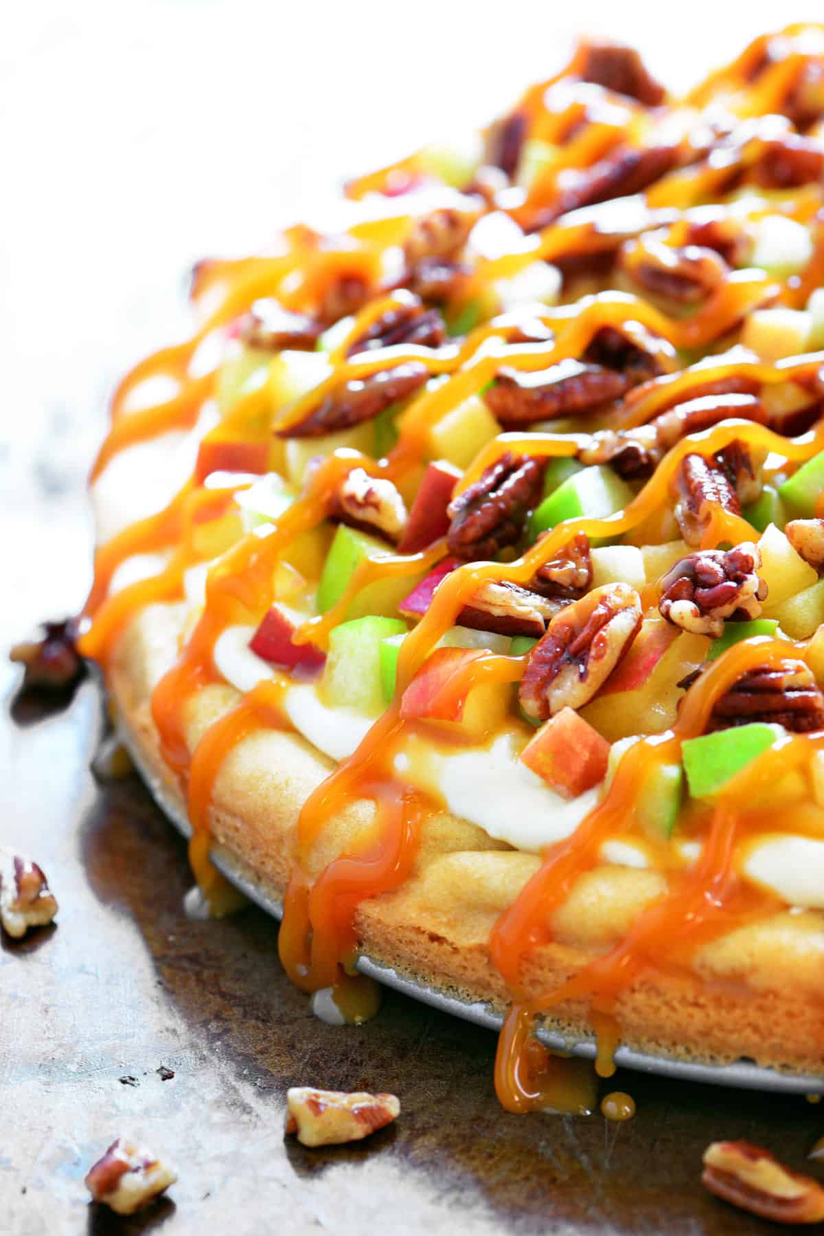 caramel apple fruit pizza with caramel drizzled on top.
