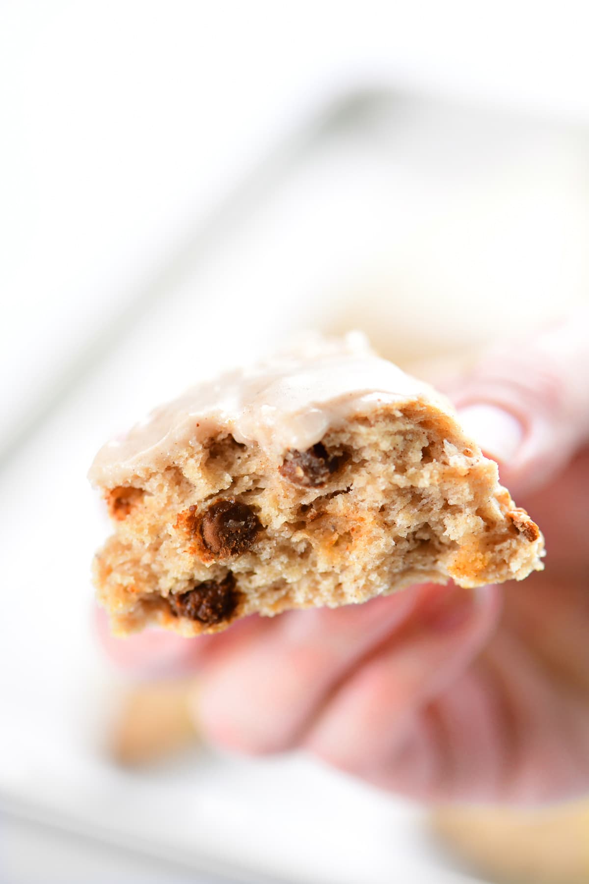 A hand holding a fluffy scone showing the inside.