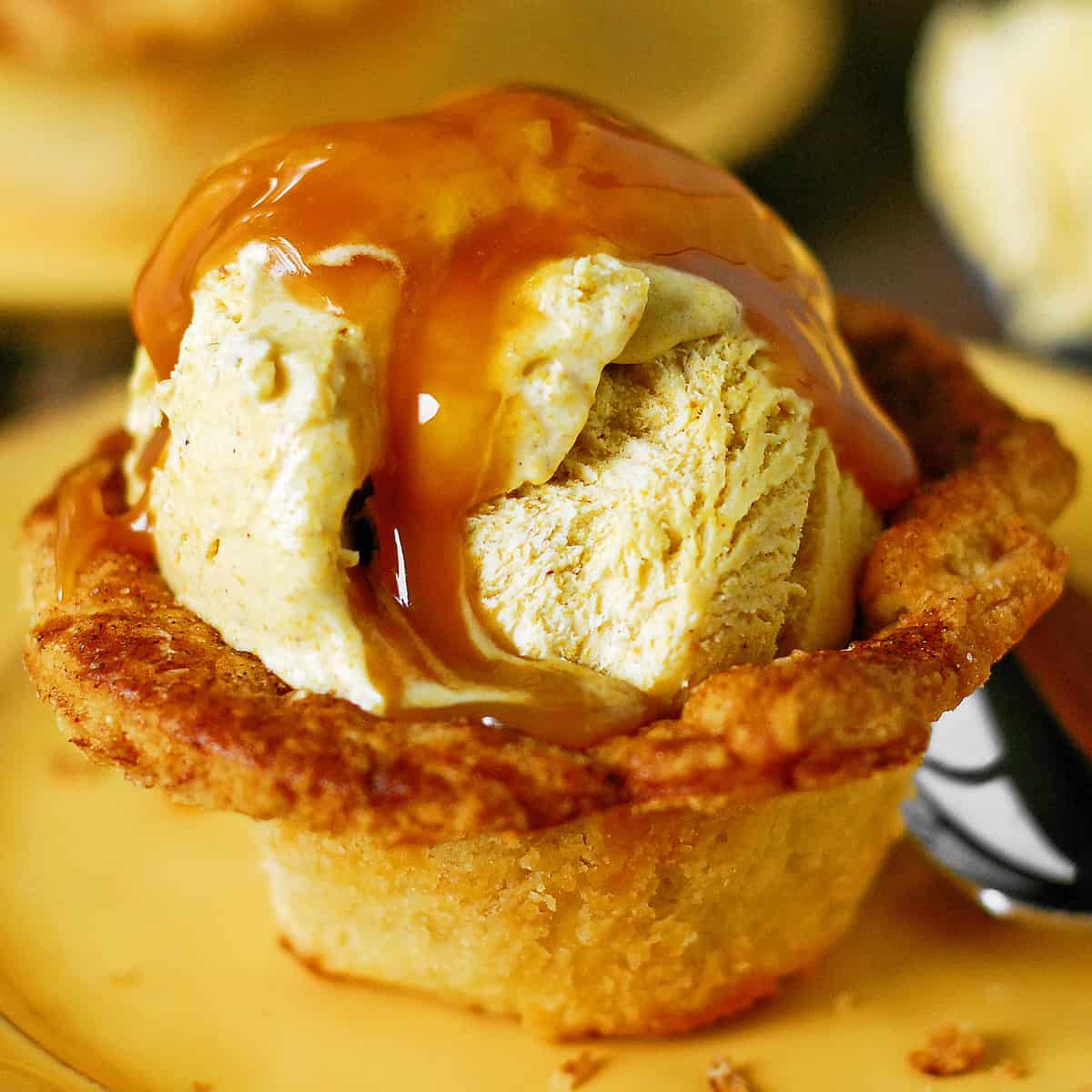 Warm caramel drizzled over pumpkin ice cream in a pie crust cup.