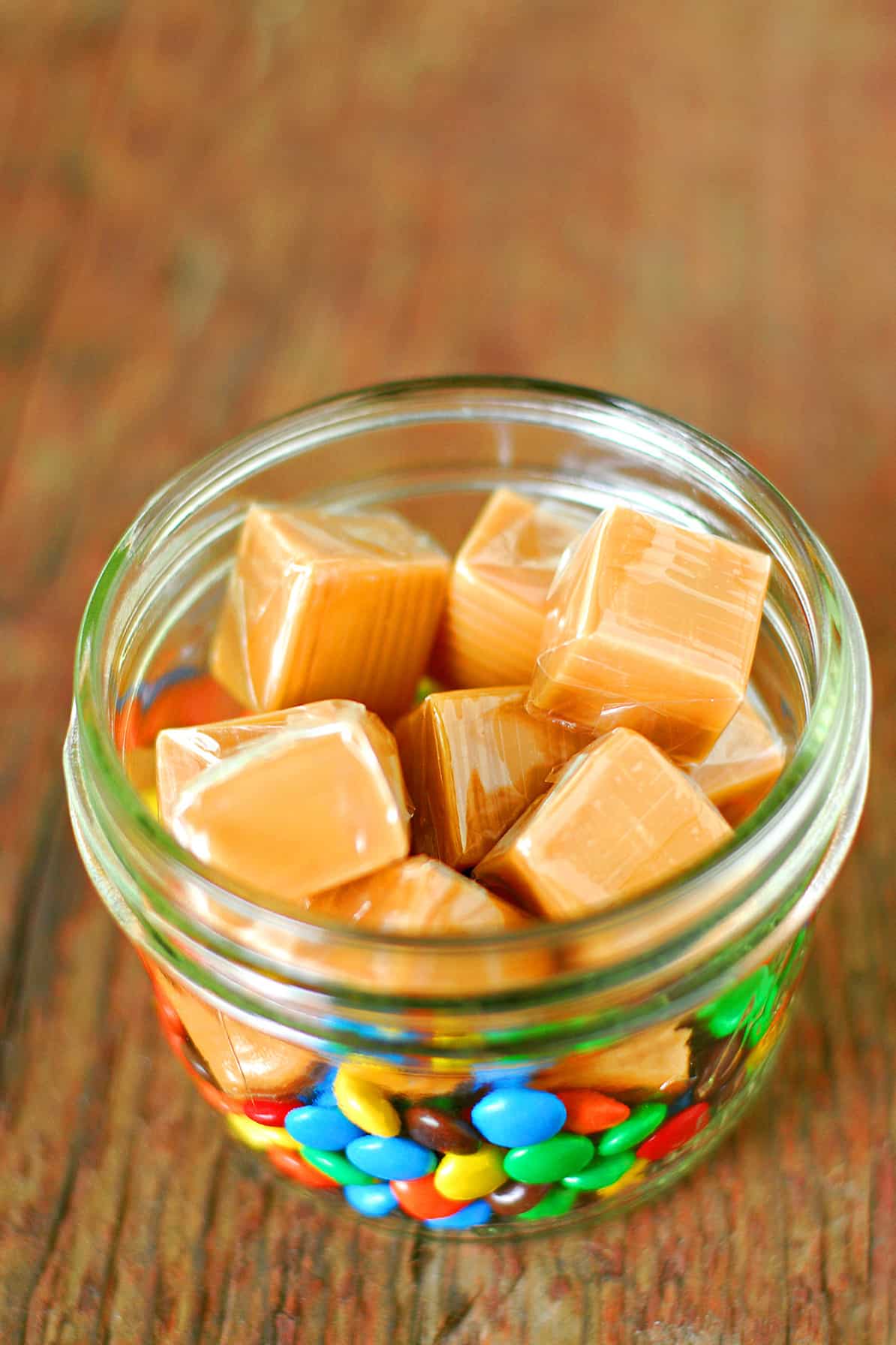 Wrapped caramels in a jar of M&M's.