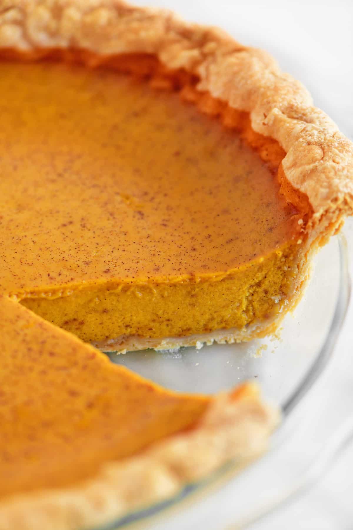 A slice removed from a pumpkin pie.