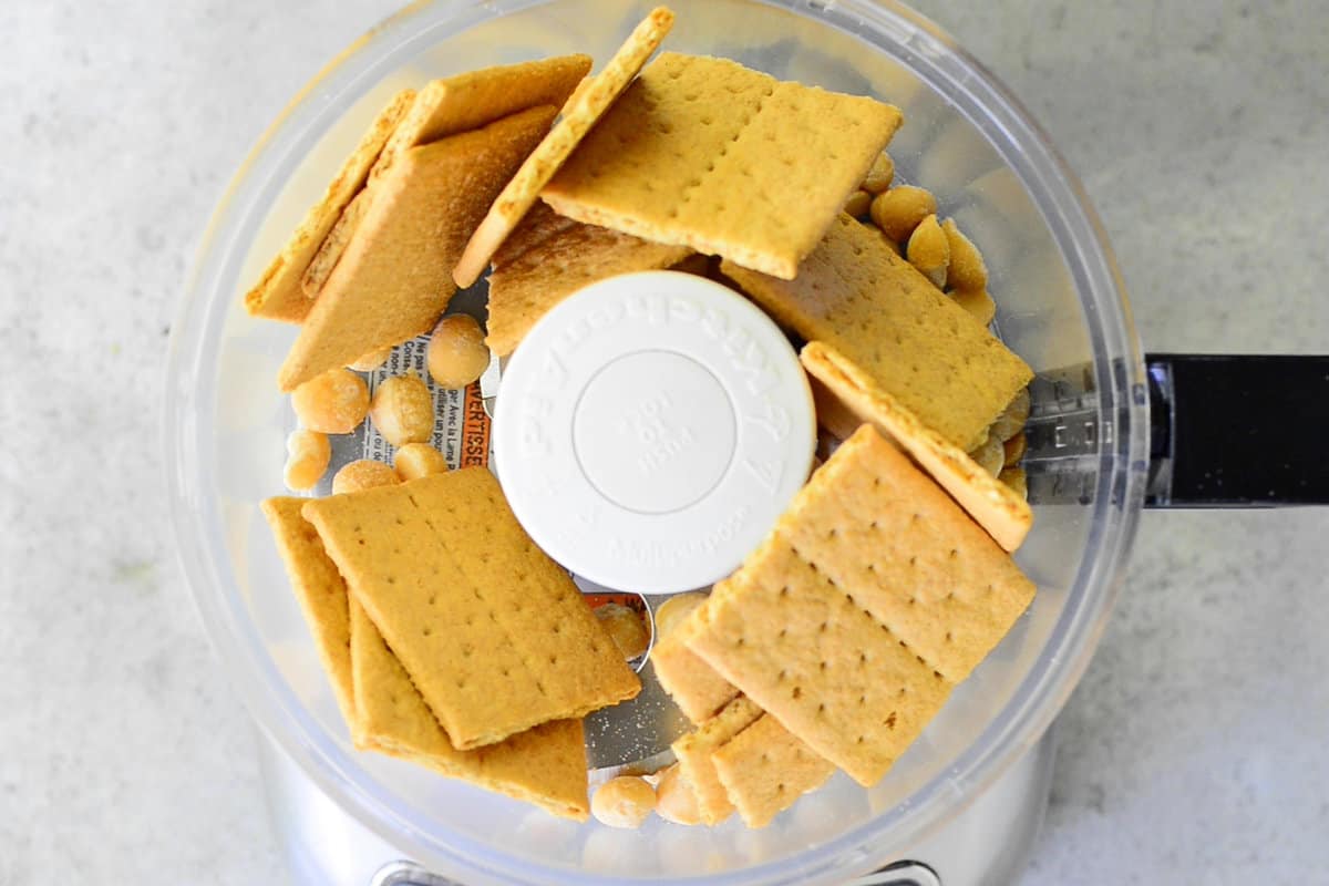 Graham crackers and macadamia nuts in a food processor.