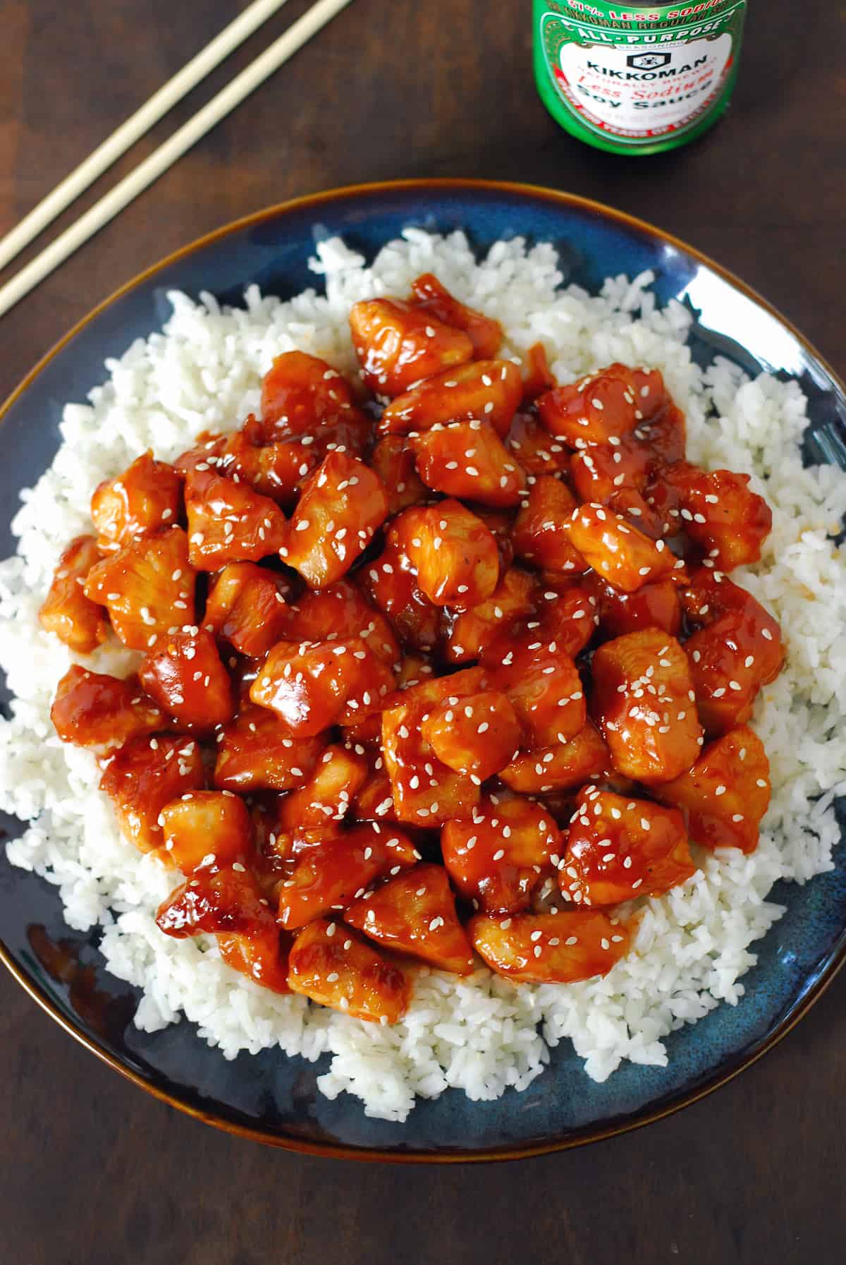 Orange chicken with rice on a blue plate.