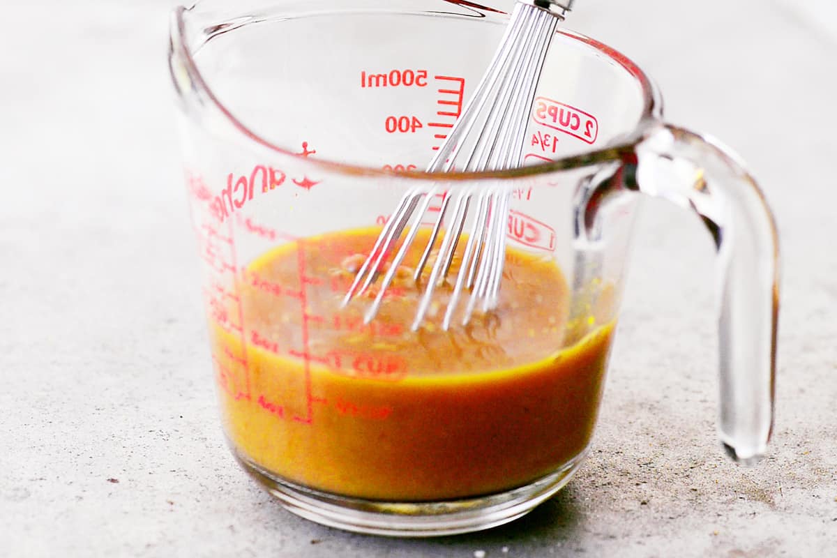 Orange sauce for chicken in a measuring cup.